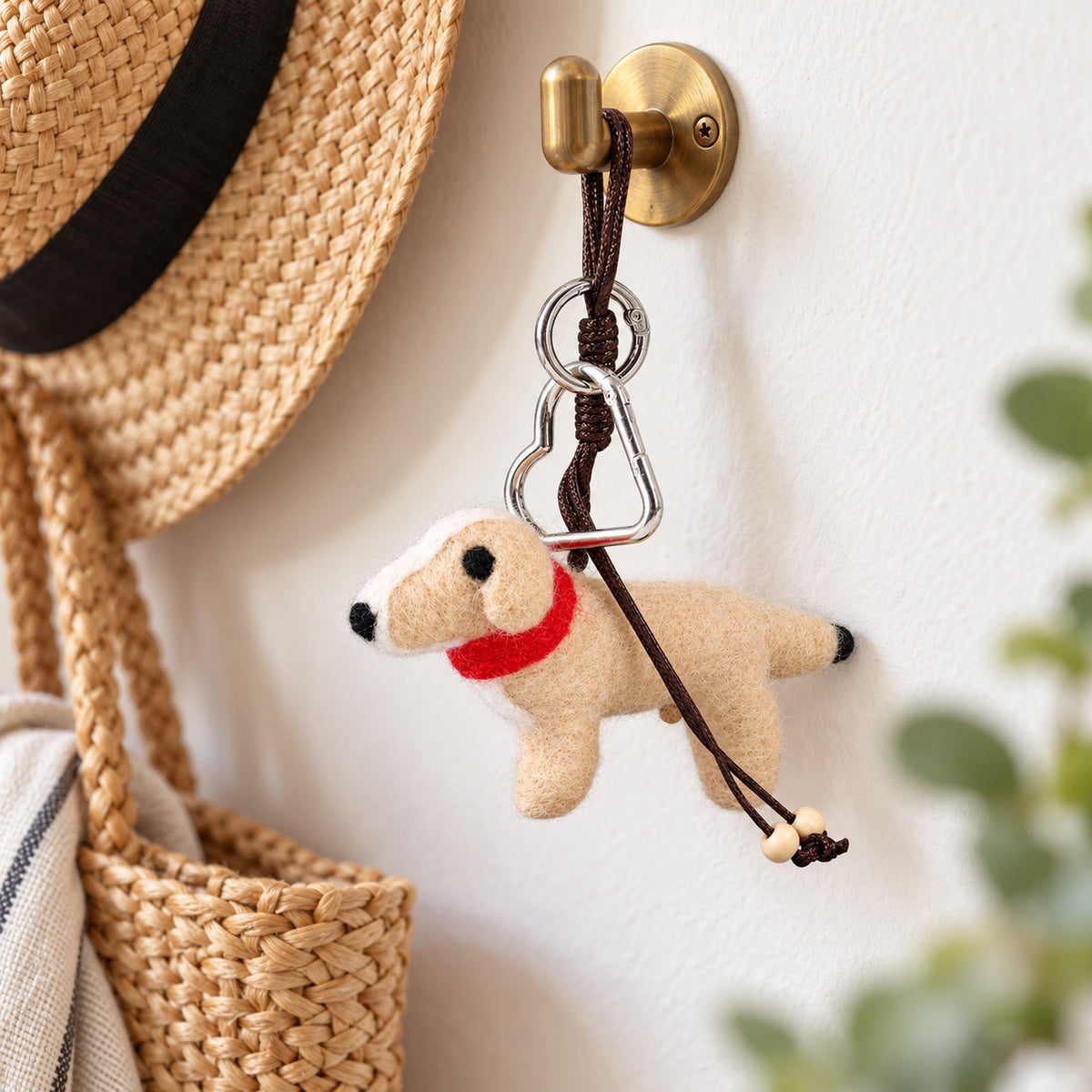 Barley the Pup, a cream felt dog bag charm with dark eyes, a black nose and a bright red scarf.