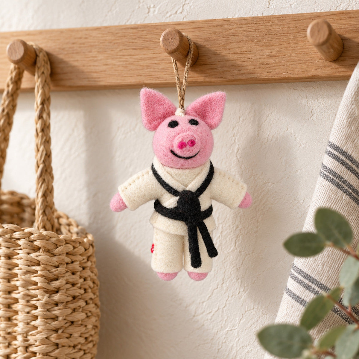 Black Belt Pig, a pink felt pig ornament wearing a white taekwondo suit with a black belt, beside a card recording the year and a training memory.